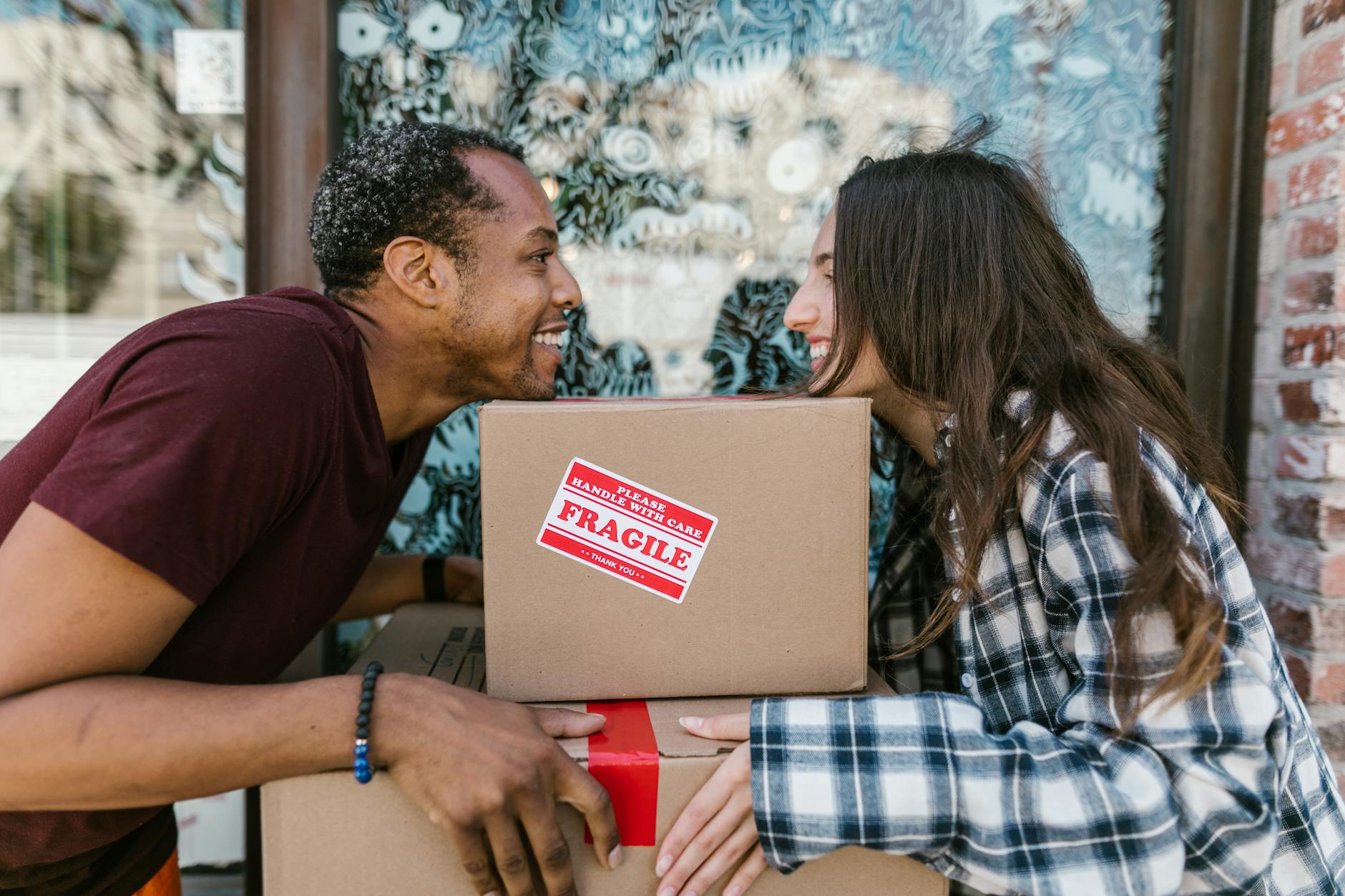man in blue white and black plaid dress shirt holding brown box