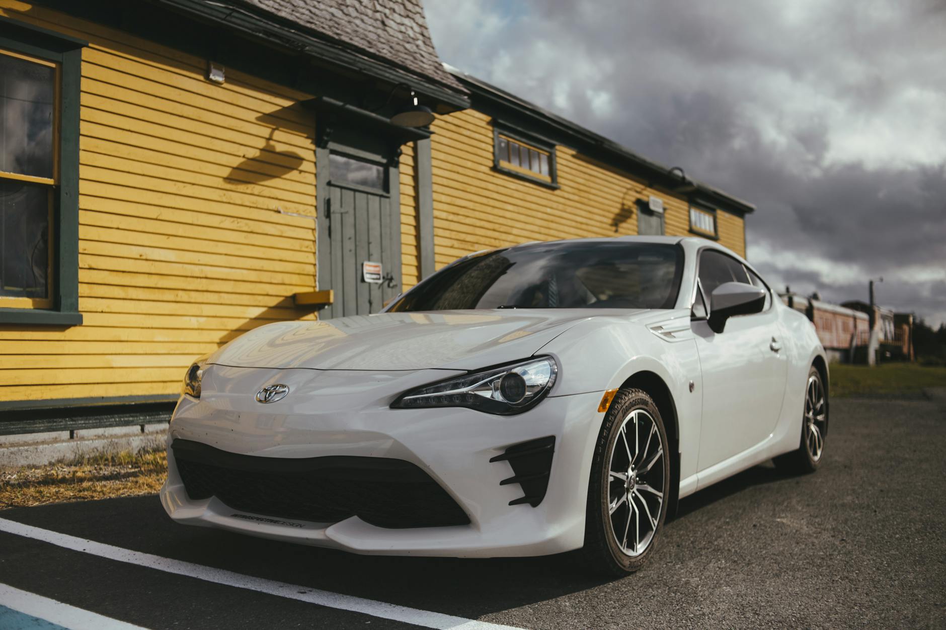 a white coupe car parked on the road