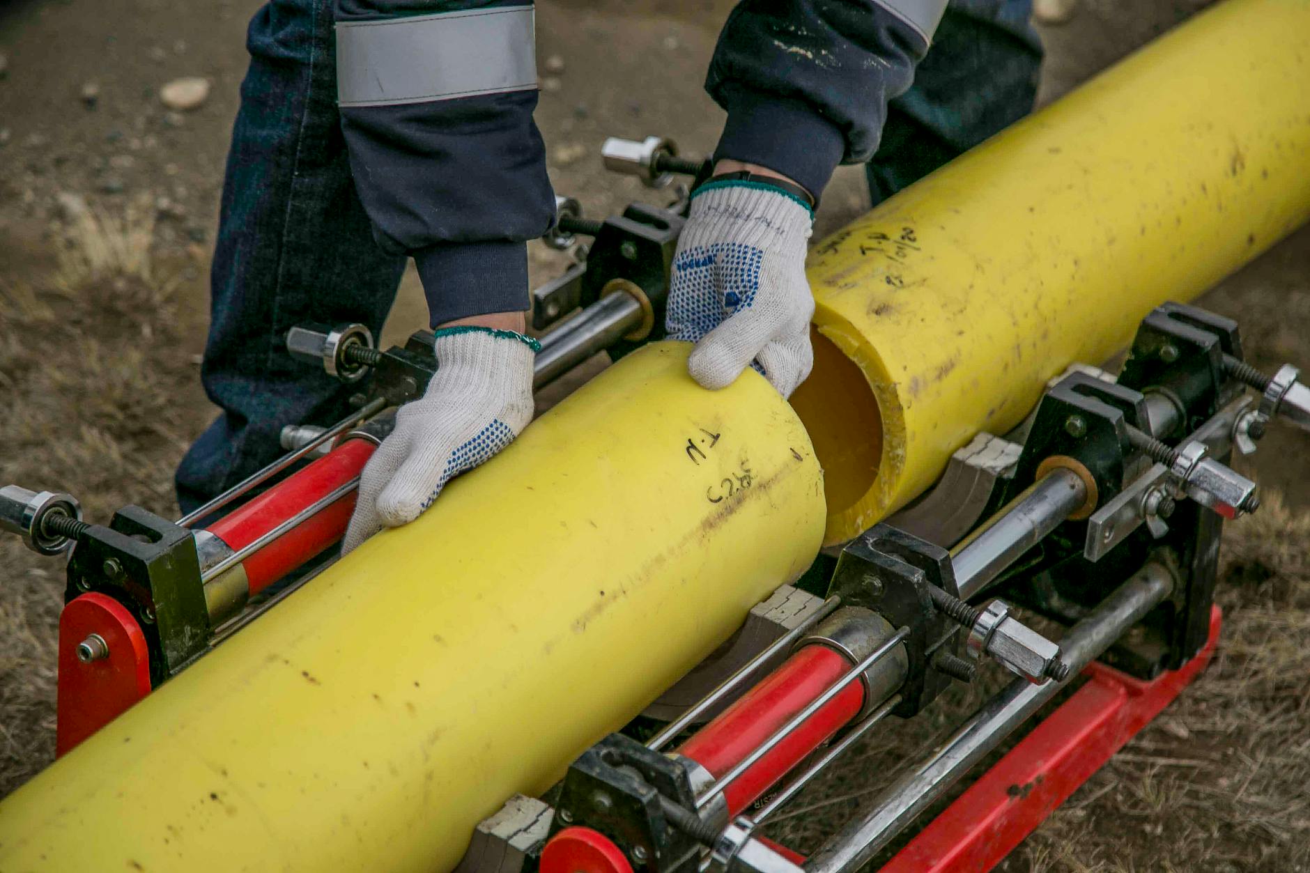 a person holding yellow pipes